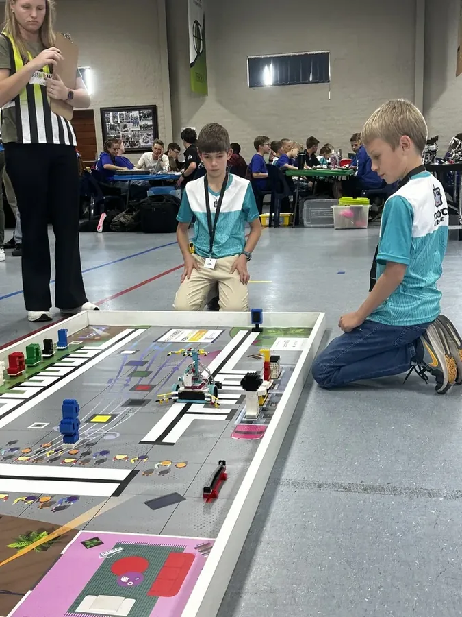 Students and a judge at the WRO game mat